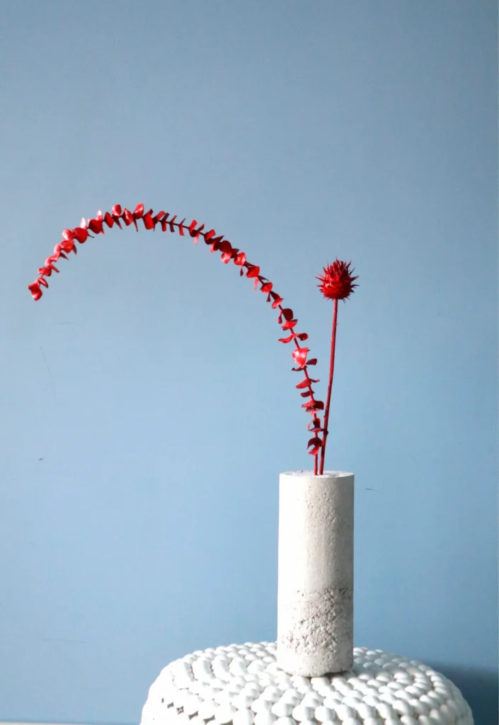 CONCRETE, PAINTED EUCALYPTUS PLANT AND THISTLE FLOWER